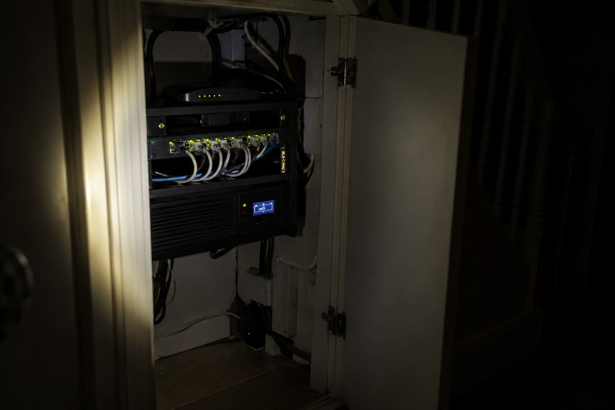 Power cut by torchlight: an understairs network cupboard still running on its UPS