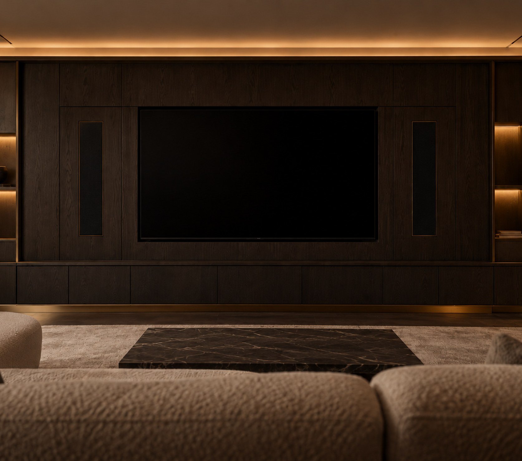 Private media room with a screen set into dark oak joinery and flush speaker grilles under warm cove lighting